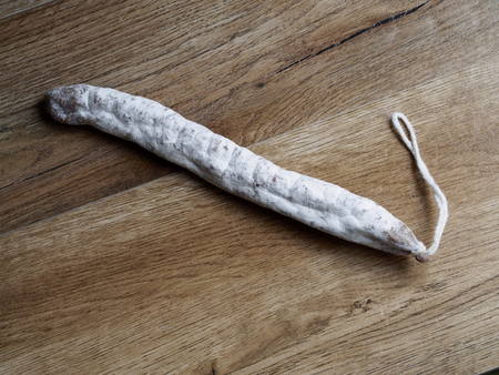 Fuet - Spanish sausage - on wood backgroundの写真素材
