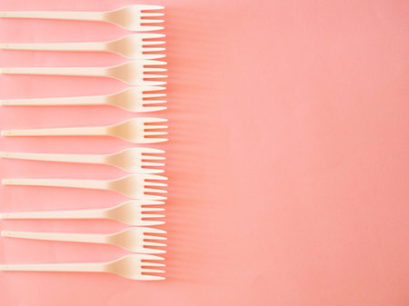Plastic fork pattern on pink background