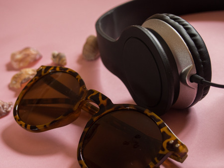 Sunglasses, earphones and seashells on pink background - Summer conceptの写真素材