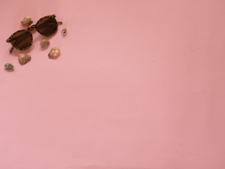 Sunglasses and seashells on pink background with copy space - Summer conceptの写真素材
