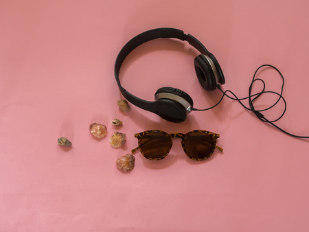 Sunglasses, earphones and seashells on pink background - Summer conceptの写真素材