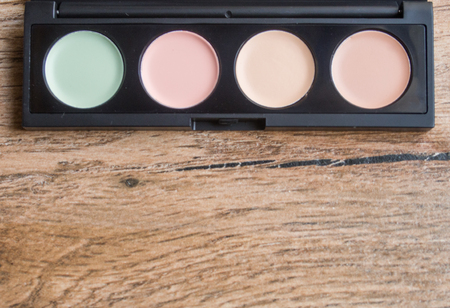 Palette with different makeup correctors on wood backgroundの写真素材