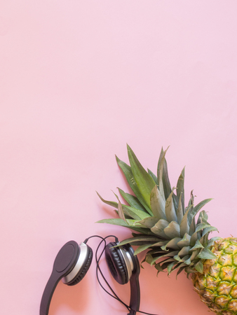Pineapple and earphones on  pink background with copy space- summer music conceptの写真素材