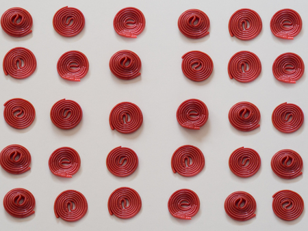 Red licorice candies pattern on white backgroundの写真素材