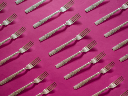 Silver forks pattern on strong pink backgroundの写真素材