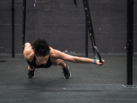 Exercising woman holding gymnast rings