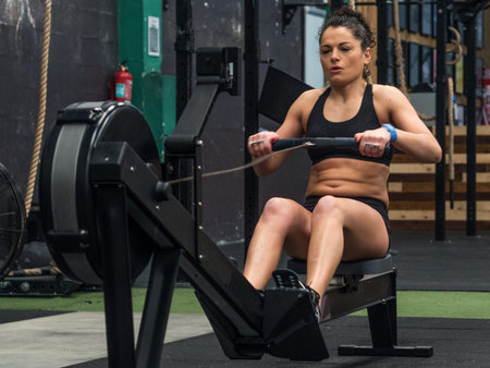 Woman training in the gym with the rowing machine