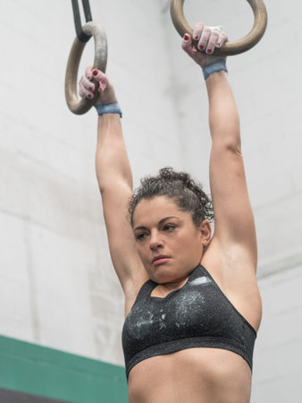 Woman athlete hung of the rings in the gymnastic