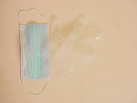 Sanitary mask with plastic glove on creamの写真素材