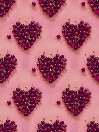 Cherries heart pattern on pink backgroundの写真素材