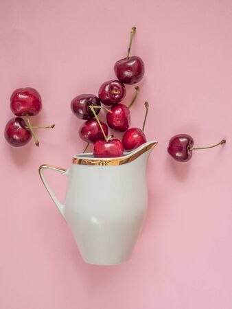 Cherries in white bowl on pink backgroundの写真素材