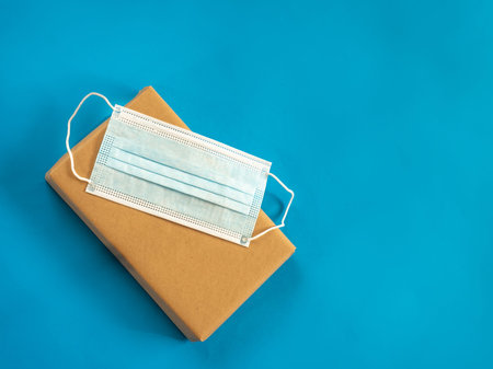 Package with mask on blue background with copy space - Secure deliver concept