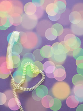 Telephone handset with heart on purple backgroundの写真素材