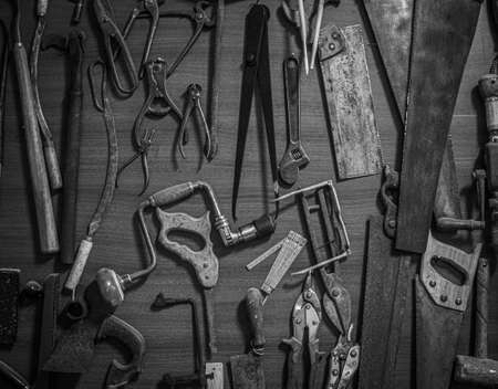 Old carpentry tools on an old workbench in black and whiteの写真素材