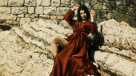 Girl in the red dress posing at front of the cameraの写真素材