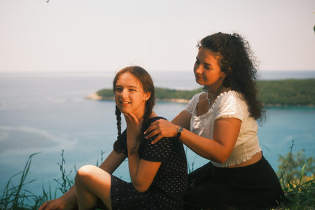 Mum holding her daughter by the shoulders. The sea in the backgroundÑ Cinematic imageの写真素材