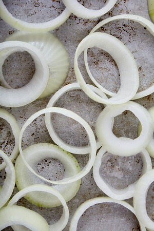 A lot of fresh, raw, crisp white onion cut into rings on a metal grunge background. Preparation for delicious fried onion rings. Natural food. Close up shot, selective focus, soft edgeの写真素材