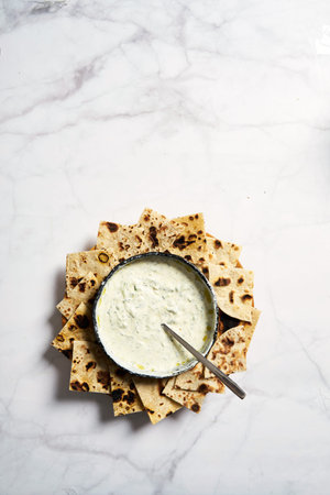 Tzatziki sauce with pan roasted pita bread. Homemade greek sauce from yogurt, dill and cucumber.Top viewの写真素材