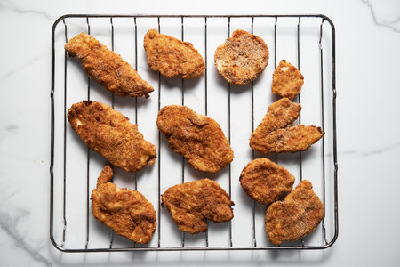Close Up of Baked Chicken Schnitzel in breadcrumbs schnitzel on grid.の写真素材