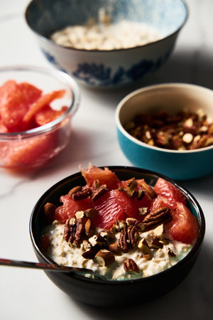 Overnight oats with milk and greek yogurt. healthy breakfast with nuts with grapefruit, honey and cinnamonの写真素材