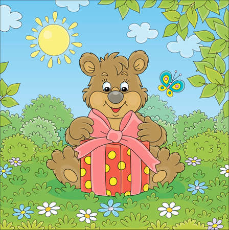 Friendly smiling little brown bear cub holding a beautiful box with a holiday gift on green grass of a pretty forest glade on a sunny summer day, vector cartoon illustrationのイラスト素材