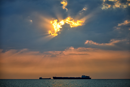 Cargo ships floating on a background of a beautiful sunset. Landscape orientationの写真素材