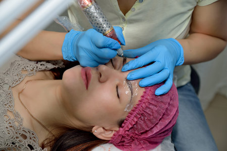 Close-up of permanent makeup. Beautician, doing permanent eyebrow tattoo in a beauty salon....