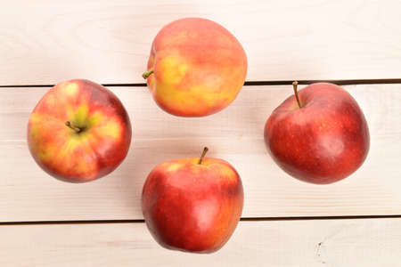 Several red organic apples on a painted wooden table.の写真素材