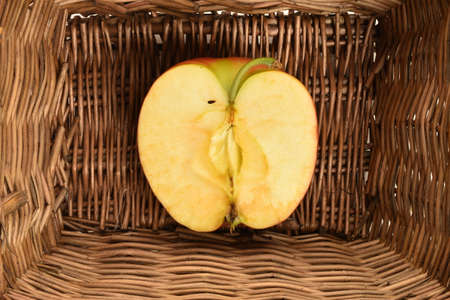 One half red fresh apple in a basket.の写真素材