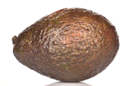 One whole dark green rounded ripe tasty nutritious avocado on a white background.の写真素材