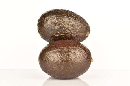 Two whole dark green rounded ripe tasty nutritious avocados on a white background.の写真素材