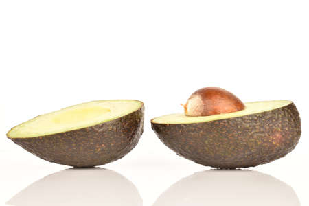 Two halves of a dark green, ripe fragrant tasty avocado on a white background.の写真素材