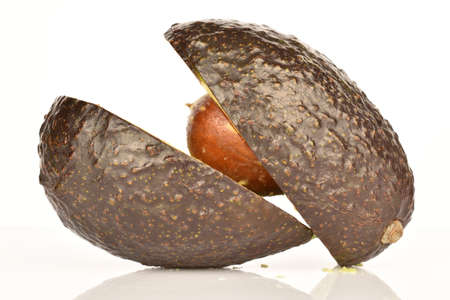 Two halves of a dark green, ripe fragrant tasty avocado on a white background.の写真素材