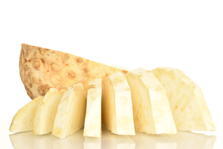 One half and sliced slices of ripe spicy juicy organic celery root, close-up, on a white background.