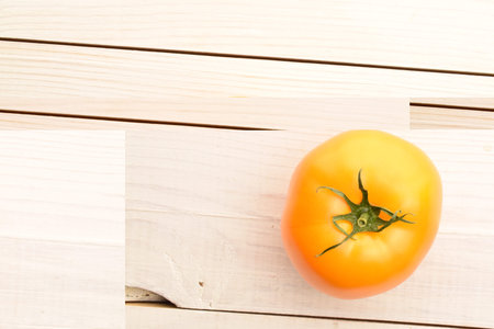 Fresh ripe, yellow tomatoes, close-up, on a painted wooden table.の写真素材