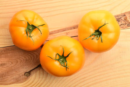 Fresh ripe, yellow tomatoes, close-up, on a wooden table.の写真素材