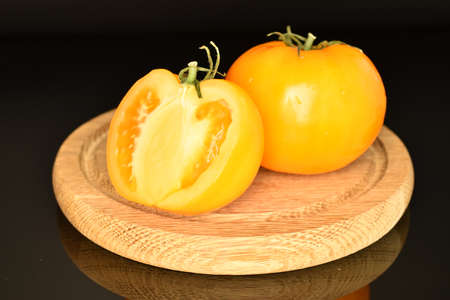 Fresh juicy yellow tomatoes, close-up, on a black background.の写真素材