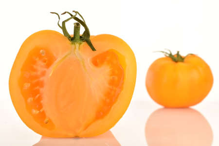 Ripe juicy, yellow tomatoes, close-up, on a painted white table.の写真素材