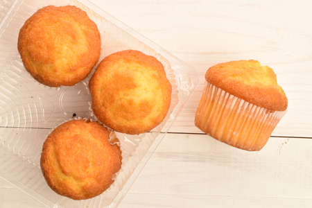 Tasty sweet muffins, close-up, on a painted wooden table.の写真素材