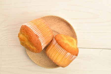 Tasty sweet muffins, close-up, on a painted wooden table.の写真素材