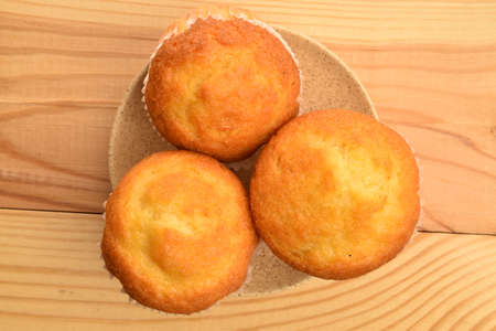 Sweet tasty muffins, close-up, on a wooden tableの写真素材