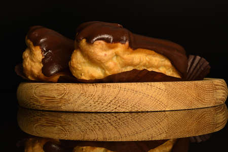 Sweet, mouth-watering chocolate eclairs, close-up, on a black background.の写真素材