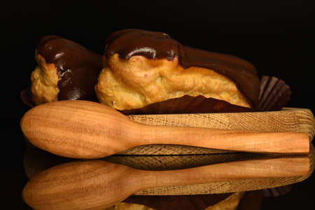Sweet, mouth-watering chocolate eclairs, close-up, on a black background.の写真素材