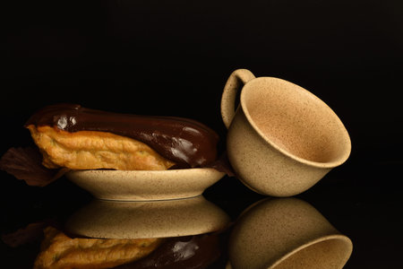 Sweet, mouth-watering chocolate eclairs, close-up, on a black background.