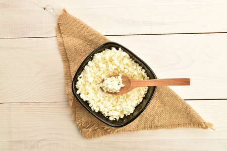 Fresh tasty, nutritious cottage cheese, close-up, on a painted wooden table.の写真素材