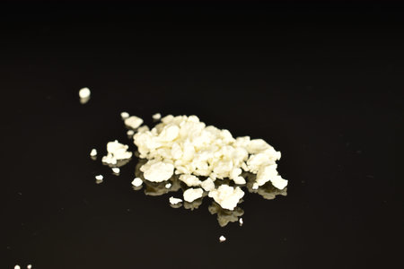 Fresh tasty, nutritious cottage cheese, close-up, on a black background.