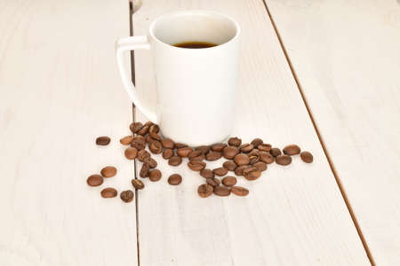 Fragrant roasted coffee grains, close-up, on a painted wooden table.の写真素材