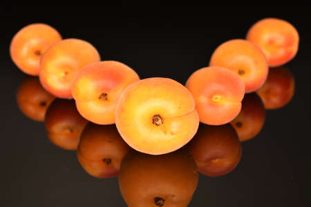 Bright yellow fresh, organic, ripe apricots, close-up, on a black background.の写真素材