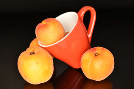 Bright yellow fresh, organic, ripe apricots, close-up, on a black background.の写真素材