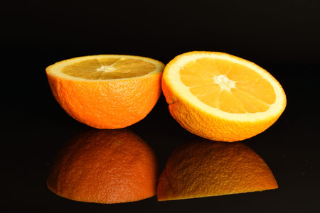 Ripe, organic orange, macro, on a black background.